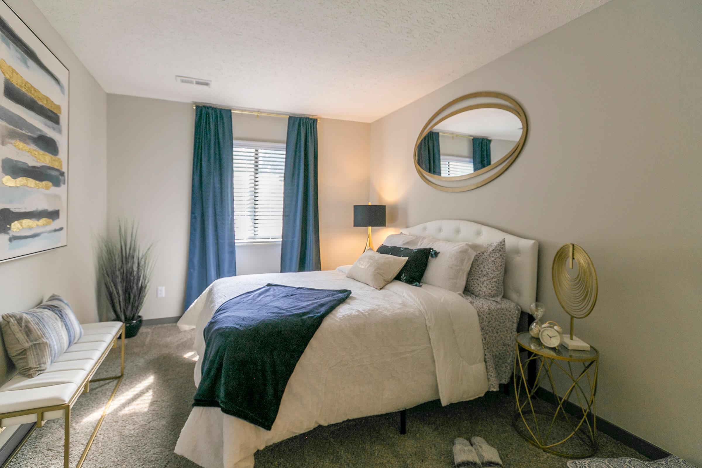 Bedroom with window, bed and blue curtains.